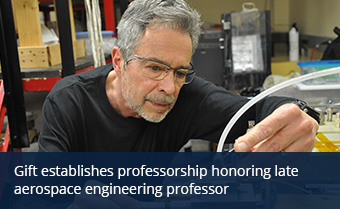 Person with gray hair and glasses touches metal box